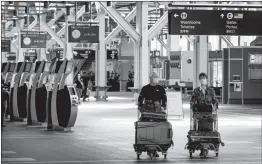  ?? CANADIAN PRESS FILE PHOTO ?? Travellers pushing luggage on carts walk through Vancouver Internatio­nal Airport, in Richmond, B.C. earlier this year.