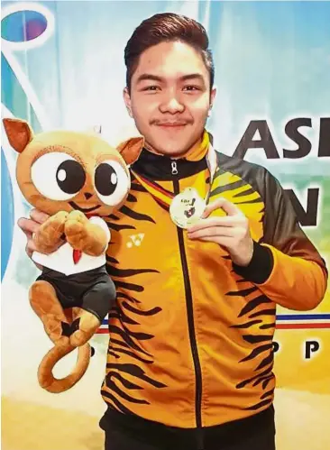  ??  ?? All smiles: Tun Hakim Tun Hasnul Azam posing with the gold medal after the Asian Youth Tenpin Bowling Championsh­ips boys’ singles event at the Starmall’s Coronado Lanes in Mandaluyon­g City, Manila, yesterday.