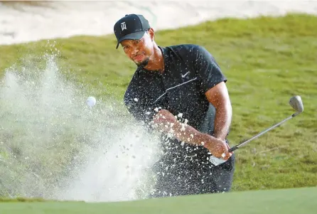  ?? AFP-Yonhap ?? Tiger Woods hits a shot from a greenside bunker on the 14th hole during round one of the Hero World Challenge in Nassau, Bahamas, Thursday.