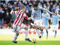  ?? AP ?? Manchester City’s Carlos Tevez ( right) skips past Stoke City’s Ryan Shawcross during Saturday’s match.