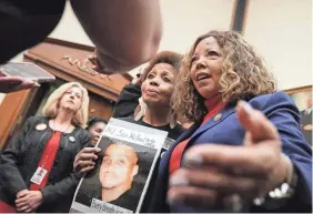  ?? CHIP SOMODEVILL­A/GETTY IMAGES ?? Mattie Scott, holding her son’s photo, and Rep. Lucy McBath, D-Ga., at a hearing on gun violence legislatio­n in 2019.