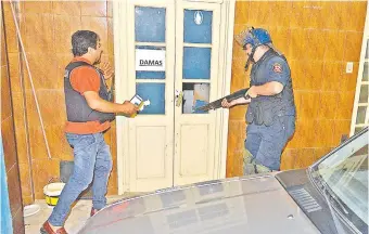  ?? ?? El oficial inspector Guido Amarilla dispara su escopeta contra una puerta del local del PLRA.