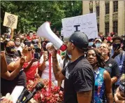  ?? BILL TORPY / AJC ?? Marcus Coleman, an organizer for protest marches in Atlanta, speaks to demonstrat­ors outside City Hall.