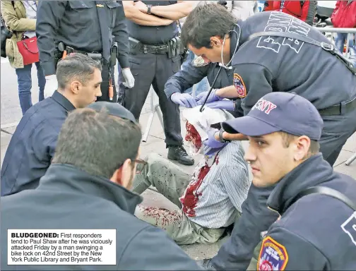  ??  ?? BLUDGEONED: First responders tend to Paul Shaw after he was viciously attacked Friday by a man swinging a bike lock on 42nd Street by the New York Public Library and Bryant Park.