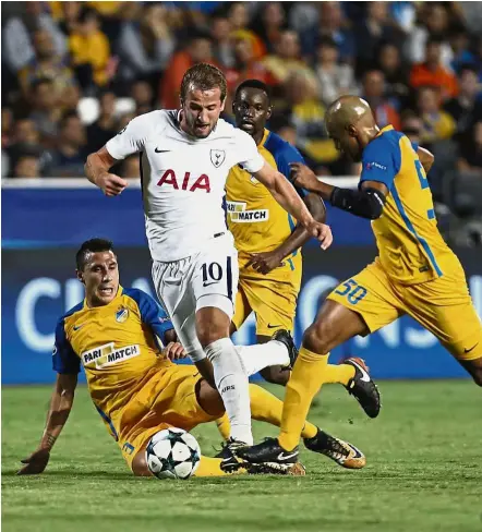  ?? —AP ?? On a roll: Tottenham Hotspur’s Harry Kane taking on Apoel Nicosia players during the Champions League match on Tuesday. Kane scored all the goals in the 3- 0 win.