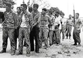  ?? MIGUEL VINAS AFP via Getty Images ?? Cuban soldiers, right, guard captured Brigade 2506 members in 1961.