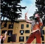  ?? -AFP photos ?? Electric violonist Andrea Casta (center) performs in the courtyard of a popular apartment building for the show Sotto lo Stesso Cielo tour (Under the same sky tour) in San Basilio suburbs of Rome.—