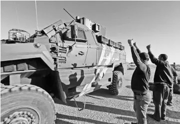  ??  ?? Tunisian men salute National Guard forces in the southern Ben Guerdane region after they exchanged fire and shot two men suspected of belonging to a jihadist group. — AFP photo