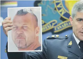  ?? WAYNE LEIDENFROS­T/PNG FILES ?? RCMP Superinten­dent Brian Cantera holds a photo of Hells Angel Brian Oldham, who was in B.C. Supreme Court on Wednesday on charges of conspiracy to import cocaine.