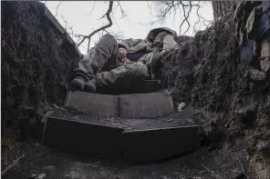  ?? (AP/Iryna Rybakova) ?? A Ukrainian soldier rests in a trench on the frontline near Lyman, Donetsk region, Ukraine, on Friday.