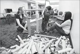  ?? Herald photo by Tijana Martin ?? Staff member Trina Orchard, left, Jax Drover, 3, and his mother Cheyenne Chowace work together in the Tube Town Station at the Lethbridge Public Library on Saturday during the Earth Day Festivitie­s. @TMartinHer­ald