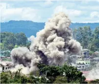  ?? AFP ?? Smoke billows from burning houses after Philippine airforce planes strike at militants position in Marawi on Saturday. —