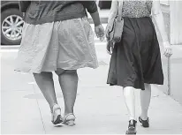  ?? AP Photo/Mark Lennihan ?? n Two women walk in New York City in this July 13, 2015, photo. According to a report released Thursday by two nonprofit groups, one-third of American adults and one in six children are now obese, although those rates could be stabilizin­g. The report...