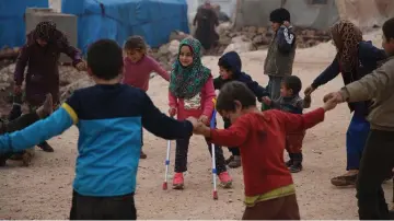  ??  ?? Maya Merhi (centre) plays with her friends in the Internally Displaced Persons (IDP) camp of Serjilla in northweste­rn Syria next to Bab al-Hawa border crossing with Turkey. — AFP photo