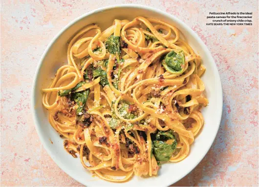  ?? KATE SEARS/THE NEW YORK TIMES ?? Fettuccine Alfredo is the ideal pasta canvas for the firecracke­r
crunch of oniony chile crisp.