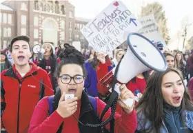  ?? Michael Ciaglo / Getty Images ?? South High School students Johnny Hultzapple (left), Aislinn Thompson and Esperanza Soledad Garcia lead a march to join striking teachers in Denver.