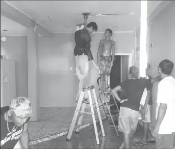  ??  ?? Some of the neighbours trying to remove a chandelier from the bottom flat, which did not suffer any damage from the fire.