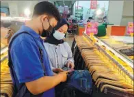  ?? PROVIDED TO CHINA DAILY ?? A retailer (right) orders goods from an agent of Chongqing-based OSell Group in Jakarta, Indonesia, on Oct 10.