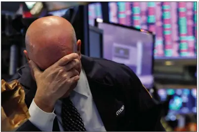  ?? (AP/Richard Drew) ?? A trader spends another tough day Thursday on the floor of the New York Stock Exchange. More photos at arkansason­line.com/313stocks/.