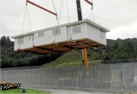  ?? SUPPLIED ?? A house built by eight prisoners is lifted over the wire at Upper Hutt’s Rimutaka Prison. It will be used as a state house in Lower Hutt.