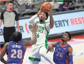  ?? JOSE JUAREZ/AP ?? Celtics guard Marcus Smart, center, drives between Pistons center Isaiah Stewart, left, and guard Josh Jackson during the first half on Sunday.