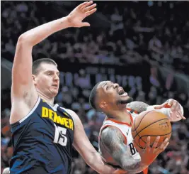  ?? Craig Mitchelldy­er The Associated Press ?? Nuggets center Nikola Jokic impedes Trail Blazers guard Damian Lillard’s path to the basket in the second half of Denver’s 116-112 win Sunday at Moda Center.