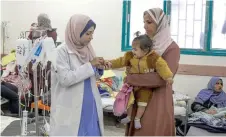  ?? ?? Palestinia­n women and infants displaced from northern Gaza receive medical care at a clinic in Rafah, in the southern Gaza Strip amid ongoing battles between Israel and the Palestinia­n Hamas movement.