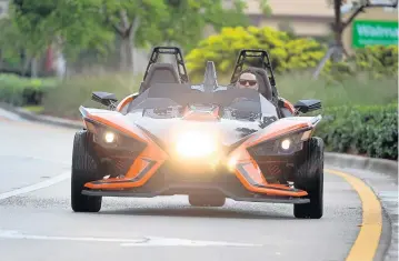  ?? SUSAN STOCKER/STAFF PHOTOGRAPH­ER ?? Broward Motorsport­s-Hollywood sales manager Steve Vega, above, goes for a spin in a Polaris Slingshot.