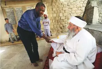  ?? AFP ?? Denis Mukwege greets Baba Shaikh Khurto Haji Esmail in the heart of Lalish temple in a valley near Dohuk, 430km northwest of the Iraqi capital Baghdad.
