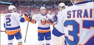  ?? ALEX BRANDON/THE ASSOCIATED PRESS ?? New York’s John Tavares, center, celebrates a second-period goal with Nick Leddy, left, and Brian Strait against the host Washington Capitals on Tuesday night.