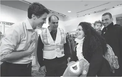  ?? NATHAN DENETTE / THE CANADIAN PRESS ?? Prime Minister Justin Trudeau greets Syrian refugees arriving at Toronto’s Pearson Internatio­nal Airport in December 2015. The numbers admitted by Canada are tiny compared to Lebanon, Jordan and Turkey.