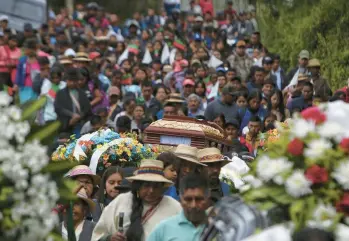  ?? ANDRES QUINTERO/AP ?? Indigenous people carry a coffin containing the remains of regional leader Wilson Bomba on Saturday through the streets of Caldono in Colombia’s southern Cauca state. Bomba was killed by gunmen Wednesday in an area where attacks against civilians are common amid armed groups fighting for control of coca cultivatio­n and drug-traffickin­g routes.