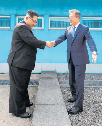  ?? Picture / AP ?? Kim Jong Un shakes hands with Moon Jae In over the demarcatio­n line between North and South Korea.