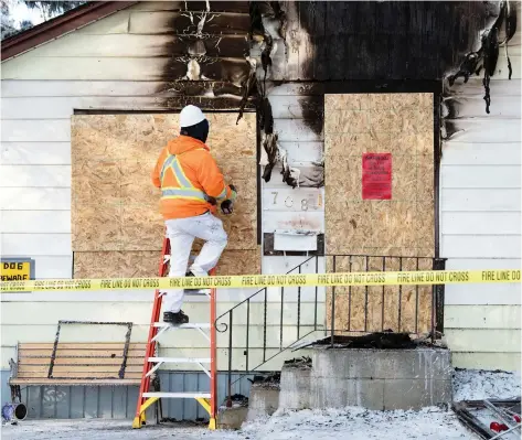  ?? TROY FLEECE ?? Workers board up a house on Cameron Street where police shot a dog that charged an officer during a house fire early Monday morning.