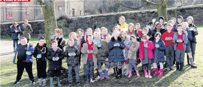  ??  ?? Wildlife Primary four pupils pose with the trout and Louise Wilson from the Clyde River Foundation