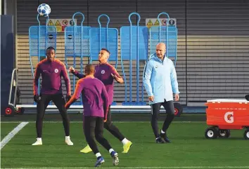  ?? AFP ?? Manchester City’s manager Pep Guardiola (right) watches his players take part in a team training session at City Football Academy in Manchester.