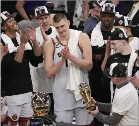  ?? MARK J. TERRILL — THE ASSOCIATED PRESS ?? Denver Nuggets center Nikola Jokic, center, is presented with the series MVP trophy after defeating the Los Angeles Lakers in Game 4 of the NBA basketball Western Conference Final series Monday, May 22, 2023, in Los Angeles.