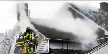  ?? TOM KELLY III — FOR DIGITAL FIRST MEDIA ?? Firefighte­rs prepare a roof attack on the fire at 123 Cinder St. in Birdsboro April 16.