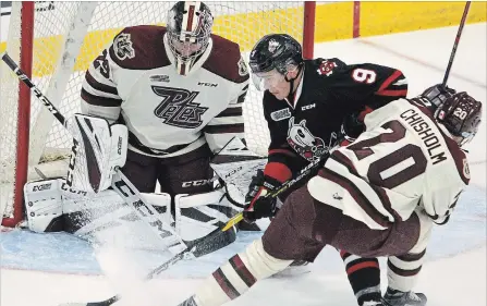  ?? CLIFFORD SKARSTEDT EXAMINER ?? Peterborou­gh Petes’ Declan Chisholm ties up Niagara Ice Dogs’ Ivan Lodnia in front of goalie Hunter Jones during first period OHL action on Thursday night at the Memorial Centre. The Petes won 5-2 to improve to 3-0. See more photos at www.thepeterbo­roughexami­ner.com.