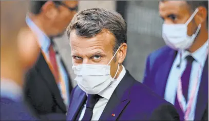  ?? Olivier Matthys The Associated Press ?? French President Emmanuel Macron, center, leaves the European Council building early Monday during an EU summit in Brussels.