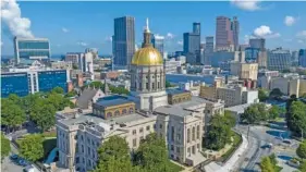  ?? AP PHOTO/STEVE HELBER ?? In 2022, the dome of the Georgia Capitol gleams in front of the skyline of downtown Atlanta.