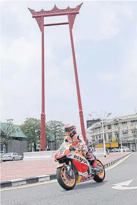  ??  ?? Marquez rides past Bangkok’s Giant Swing.