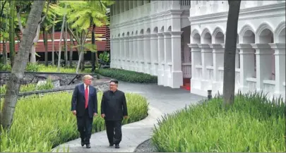  ?? KEVIN LIM / THE STRAITS TIMES ?? US President Donald Trump walks with the DPRK’s top leader Kim Jong-un at the Capella hotel on Sentosa island in Singapore on Tuesday.