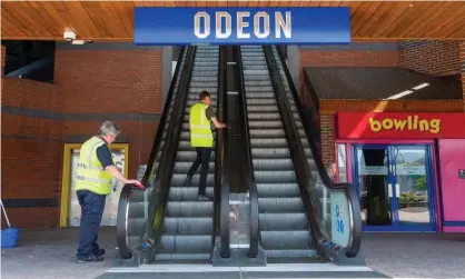  ??  ?? Cleaners work on an escalator leading up to an Odeon cinema in Bracknell, Berkshire. Photograph: Maureen McLean/Rex/Shuttersto­ck