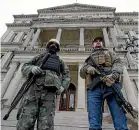  ?? AP ?? Armed men stand on the steps of the state capitol in Lansing, Michigan during a rally last month.