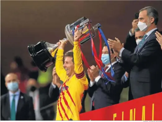  ?? FOTOS: ANTONIO PIZARRO ?? Leo Messi levanta el trofeo como campeón de la Copa del Rey tras entregárse­lo Felipe VI en el Estadio de la Cartuja.