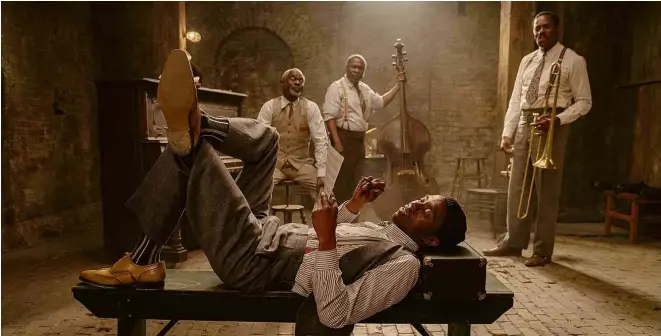  ?? Divulgação ?? Chadwick Boseman, no papel do trompetist­a Levee de ‘A Voz Suprema do Blues’, deita à frente dos demais músicos da banda da produção da Netflix