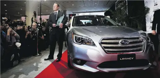  ?? Da rren Calabrese / The Cana dian Press ?? Ted Lalka, vice-president of product planning and marketing for Subaru Canada, poses next to the Subaru Legacy after the car was named the Canadian Car of the Year by the Automobile Journalist­s Associatio­n of Canada in Toronto, Feb. 12, 2015.