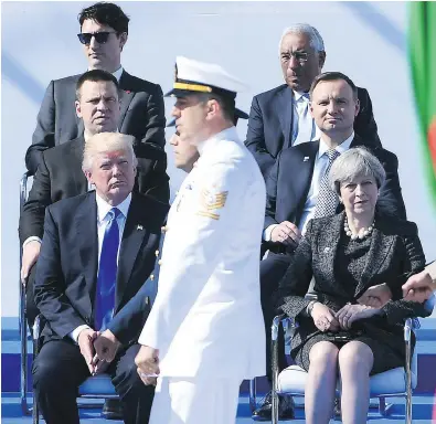  ?? EMMANUEL DUNAND / AFP / GETTY IMAGES ?? U.S. President Donald Trump and British Prime Minister Theresa May, front row, watch the military parade during the opening ceremony of the NATO summit on Thursday, where he refused to reaffirm the U.S. commitment to NATO’s Article 5.