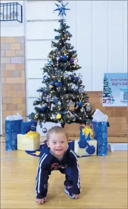  ?? VALERIE MILLER/DAILY SOUTHTOWN ?? Jay Kulik, 2, of Homer Glen, poses in front of a tree created in his honor for Down syndrome awareness by Valerie Miller and others as part of this year’s Festival of Trees Christmas Tree Decorating Contest in Lockport.